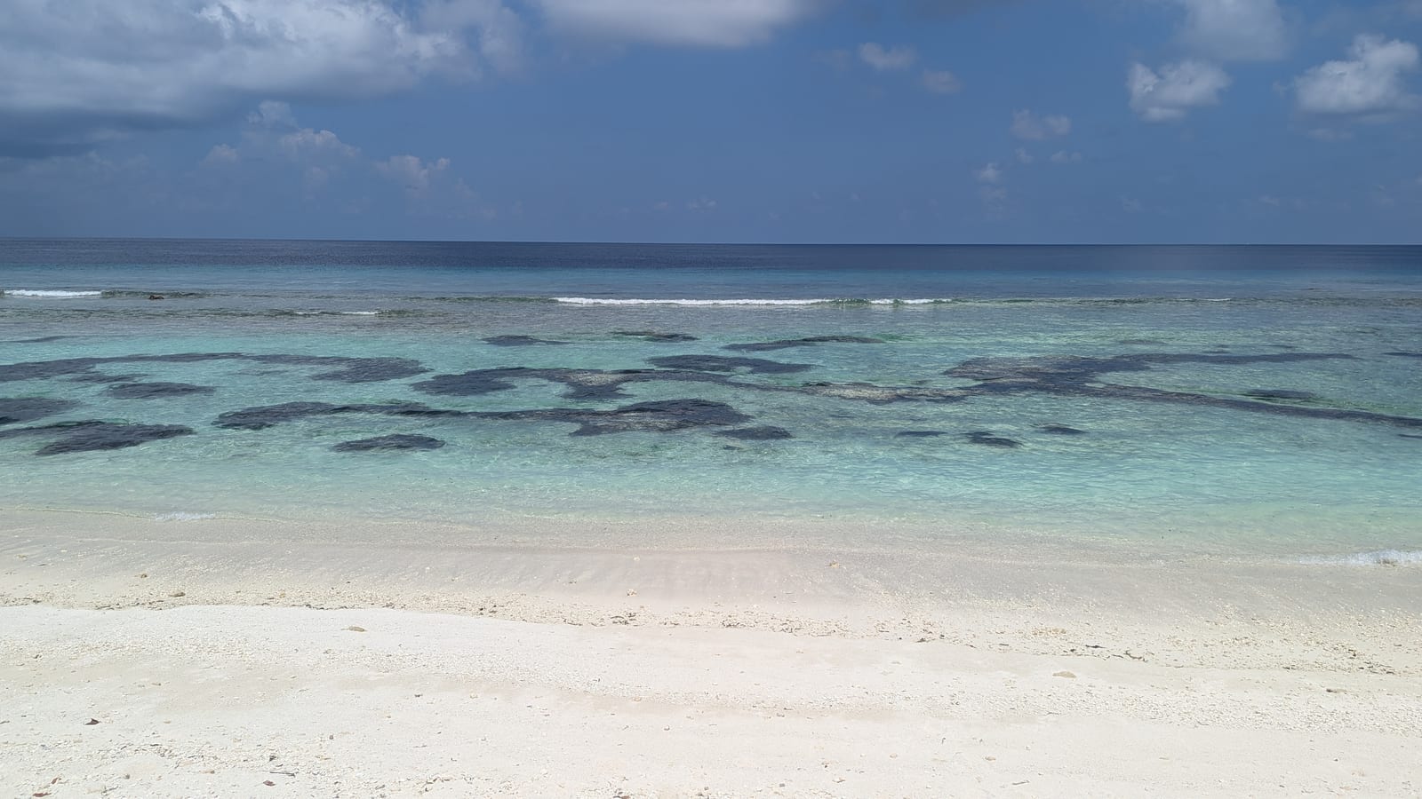 Beach and reef flats visible at low tide on Dhigurah