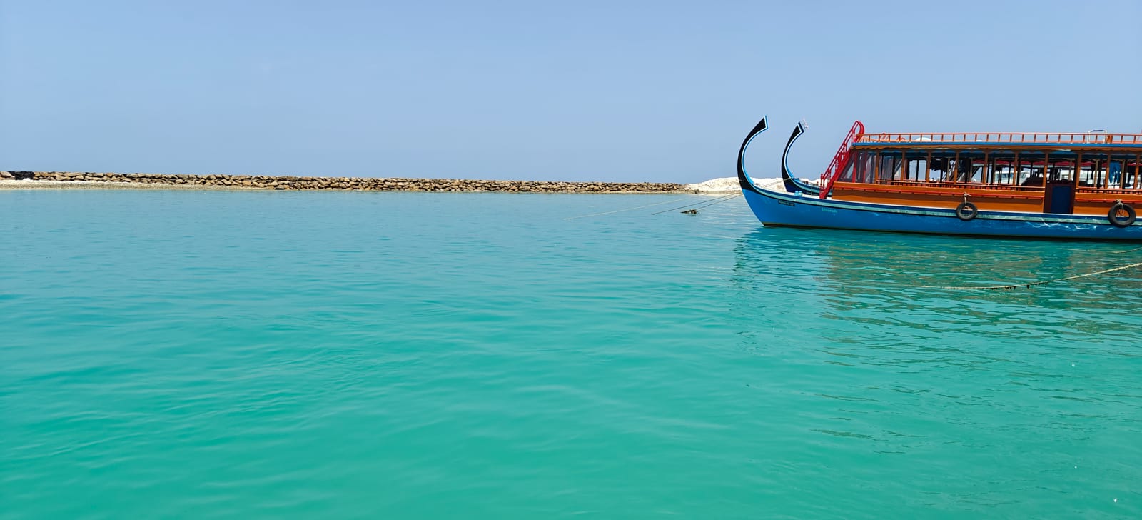 Traditional Maldivian dhoni boat moored in turquoise water