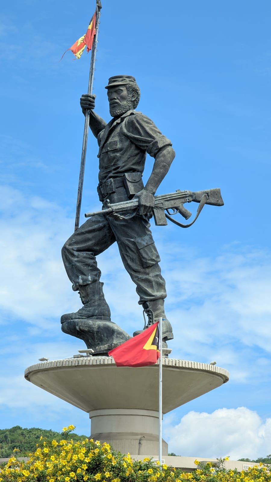A bronze statue of a FALINTIL resistance fighter holding a flag in Dili