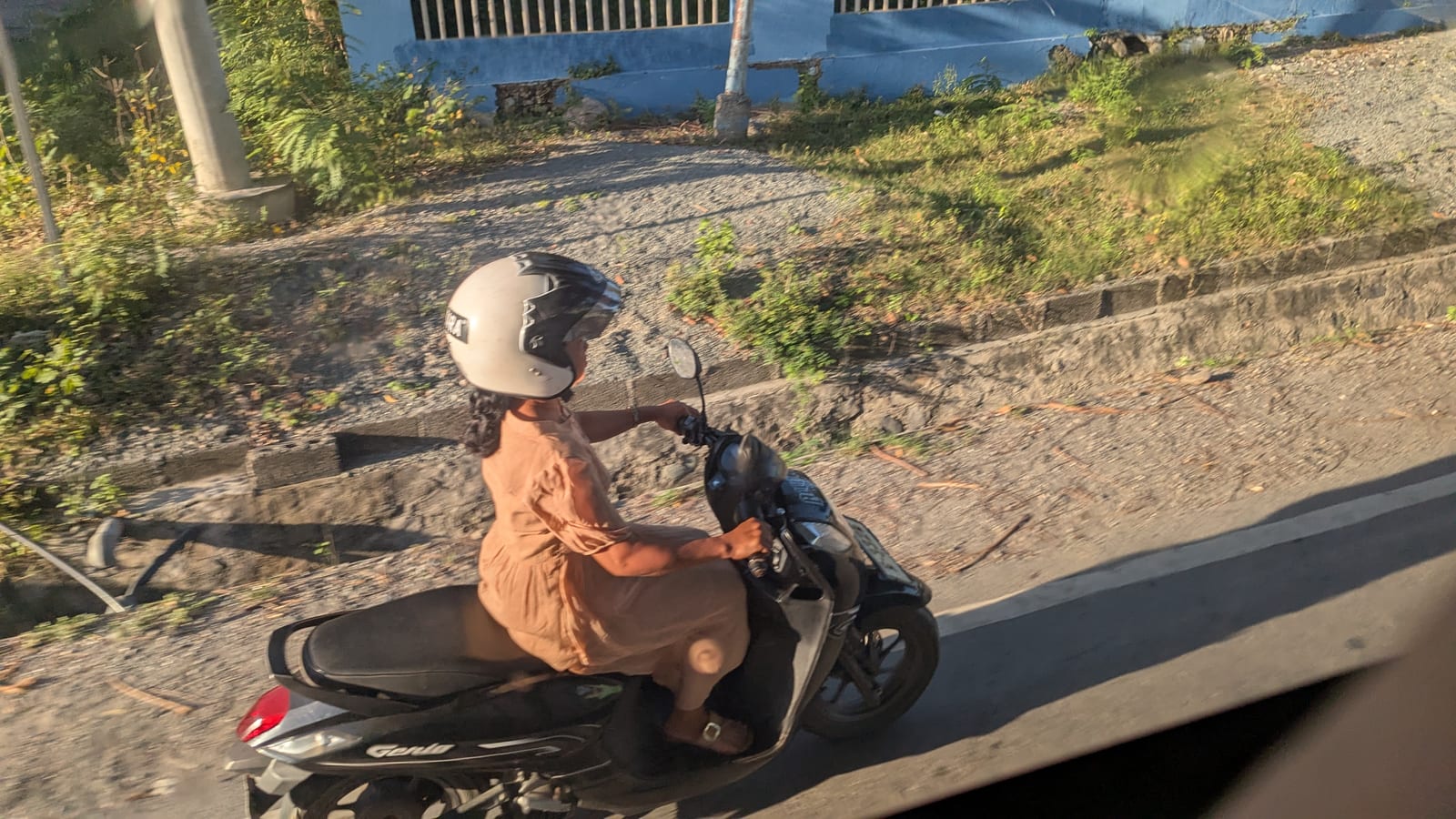 A motorbike passing on a rural road between Dili and Kupang