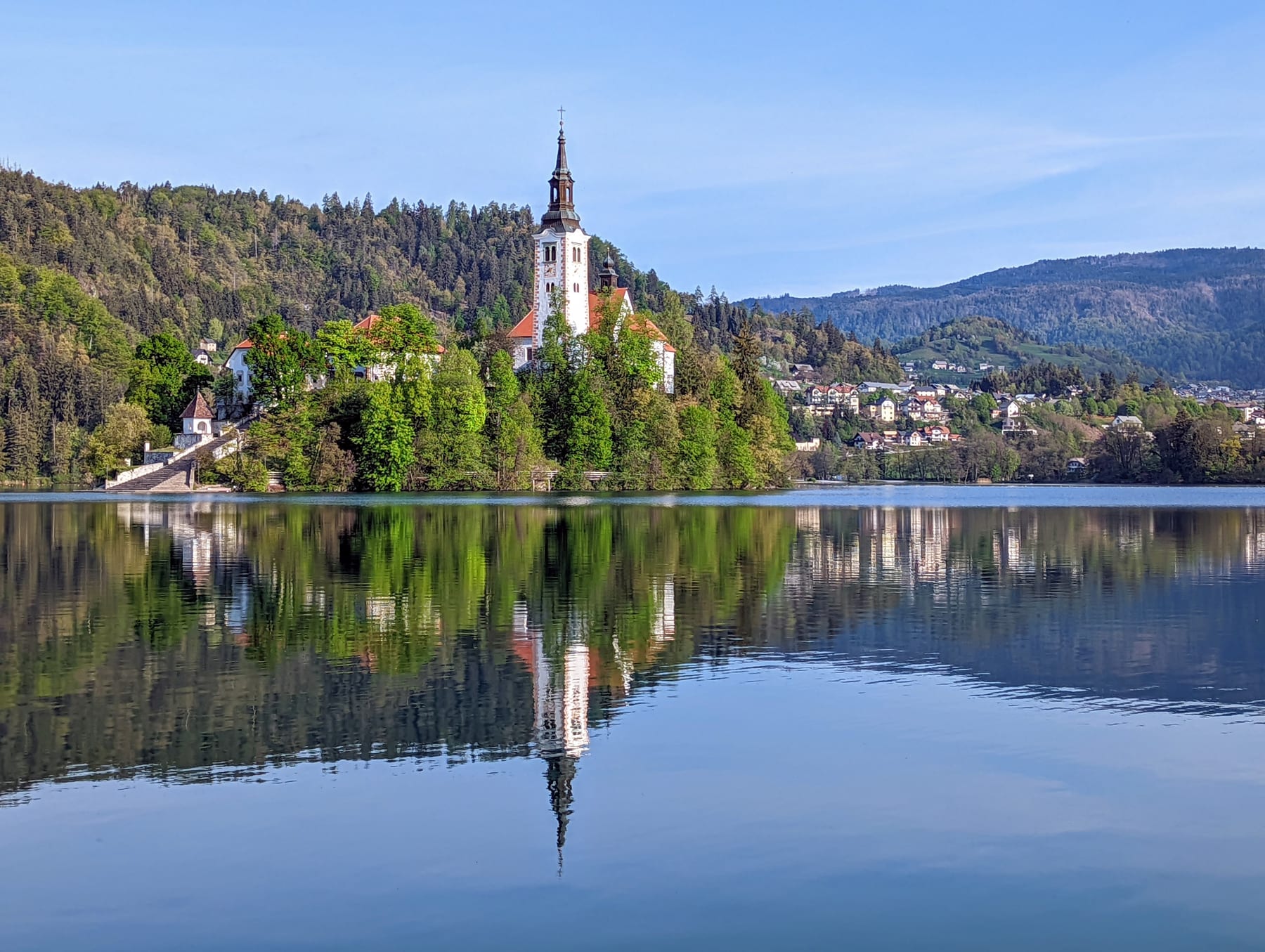 Lake Bled island and church reflected in calm morning water
