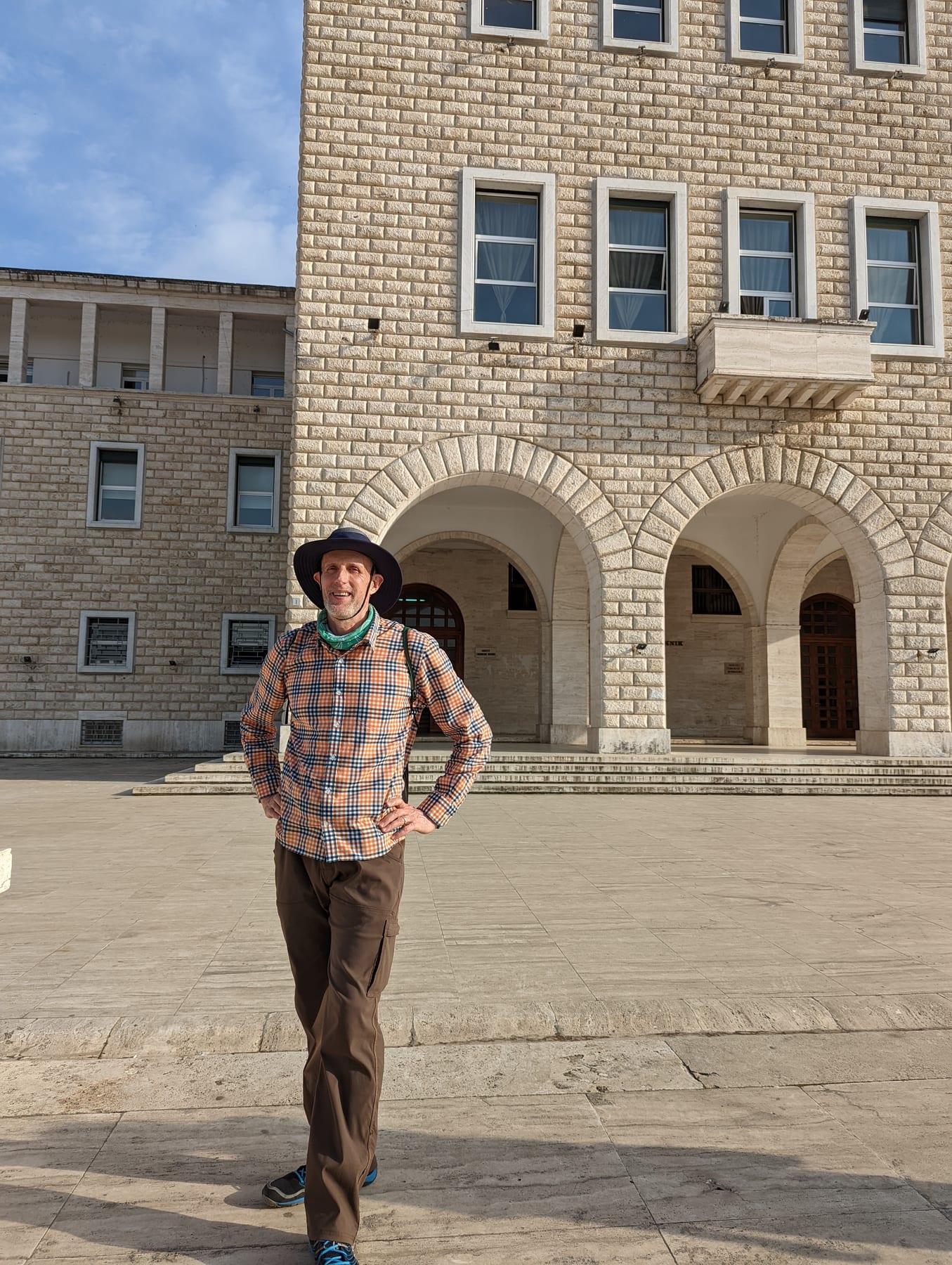 A traveler standing in Skanderbeg Square beside the National Historical Museum in Tirana
